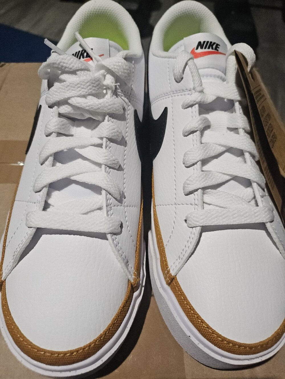 Nike White Low-Top Sneakers with Black Swoosh and Gold Trim